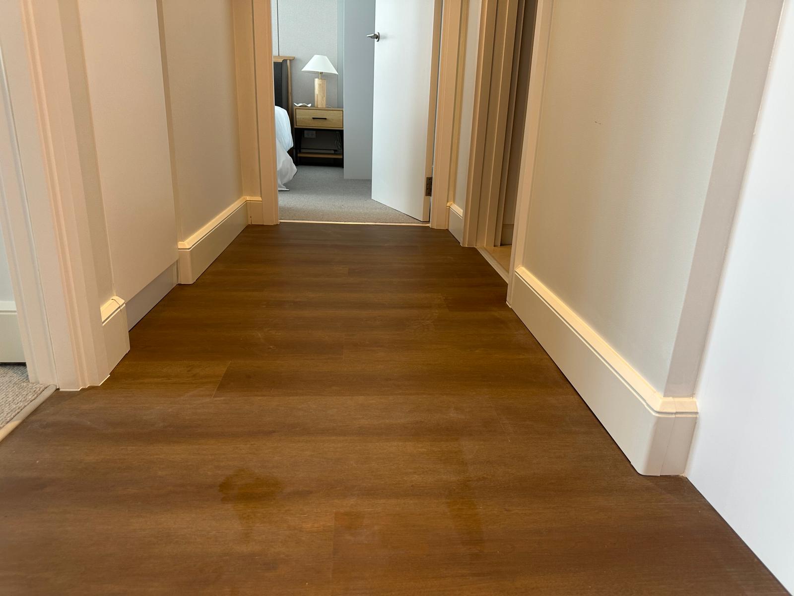 HeatENE heated baseboard installed in modern apartment hallway